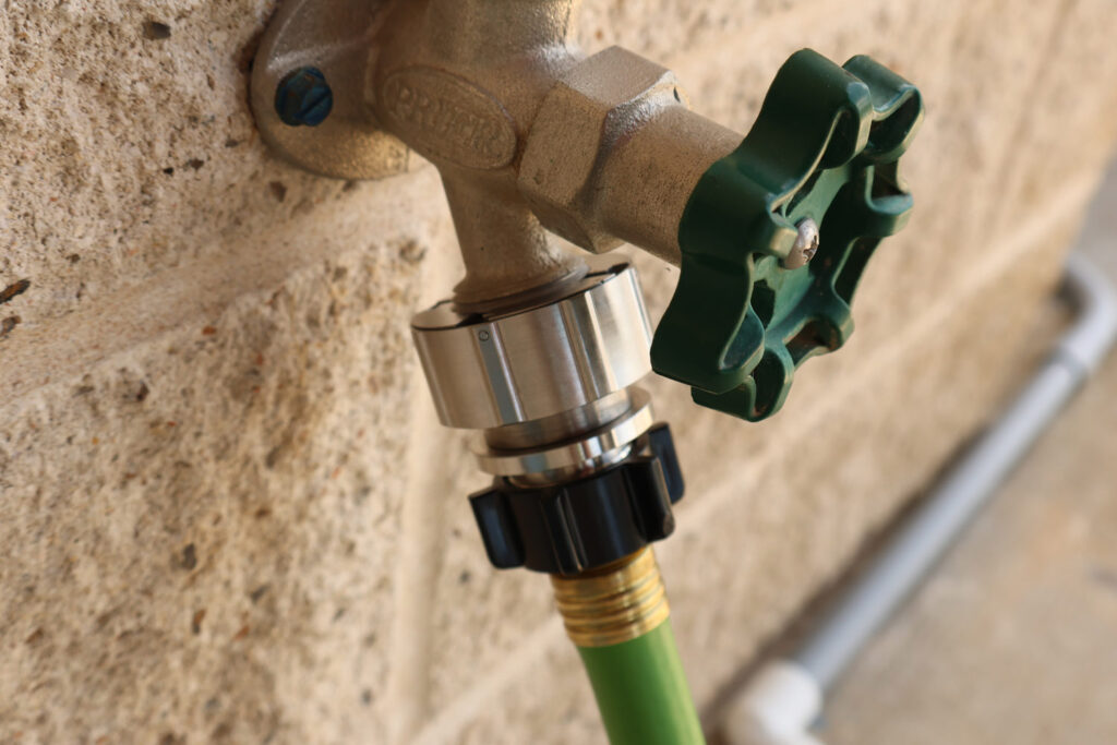 Hose Shark mounted to a brick exterior faucet with tight, secure fit.